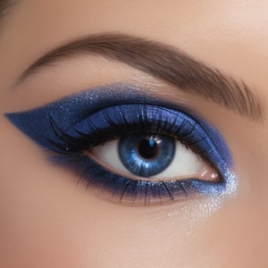 以下が含まれることがあります： ドラマチックなメイクをした青い目のクローズアップ。目は鮮やかなブルーのアイシャドウ、シャープなウィングアイライナー、濃いマスカラが特徴です。眉はきちんと手入れされており、虹彩は明るく魅力的な青色です。全体的な効果は大胆で華やかな外観です。