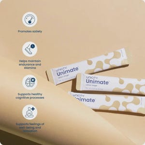 May include: Three white and beige Unicity Unimate Lemon Ginger packets are displayed on a light brown surface. The packets have a pattern of beige organic shapes. Text on the packets includes "Unimate" and "Lemon Ginger."
