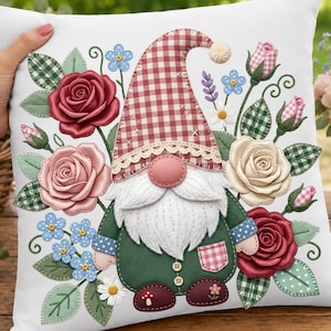 May include: White cushion featuring a gnome design surrounded by roses and other flowers. The gnome wears a red and white checked hat, a green coat, and a white beard. The cushion is decorated with various floral elements.