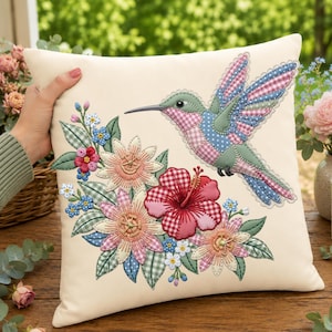 May include: Cream-colored decorative pillow featuring a colorful patchwork hummingbird and floral embroidery. The hummingbird has pink, blue, and green wings. The flowers include a red hibiscus and other blooms in pink, blue, and white.