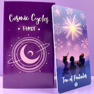 May include: A purple Cosmic Cycles Tarot deck box with a crescent moon and ring graphic, next to a Ten of Pentacles tarot card featuring four figures sitting on a hill watching yellow fireworks in a purple night sky with white text.