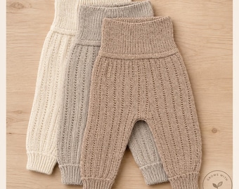 May include: Three pairs of knit leggings in cream, light gray, and tan. Each pair features a high ribbed waistband, a vertical textured knit pattern along the legs, and ribbed cuffs at the ankles. The garments are arranged in a layered stack.
