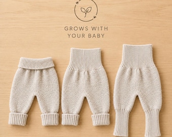 May include: Three pairs of beige knit pants with high ribbed waistbands and ribbed cuffs. The pants are arranged in increasing size order. Above the pants, a circular logo features a leaf icon and the text GROWS WITH YOUR BABY.