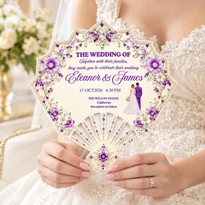 Op de afbeelding: Een waaiervormige huwelijksuitnodiging in crème met paarse bloem- en kristalachtige versieringen. De tekst luidt: THE WEDDING OF, Together with their families, they invite you to celebrate their wedding, Eleanor & James, 17-OCT2026 4:30 PM, THE WILLOW ESTATE, California, Reception to follow. Bevat een illustratie van een koppel.