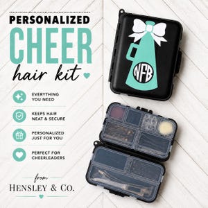 May include: A black rectangular plastic storage case with a teal megaphone and white bow graphic featuring the monogram NFB. The case is shown both closed and open, revealing multiple internal compartments filled with various hair accessories.