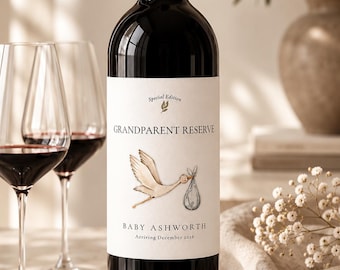 May include: A dark glass wine bottle with a white label featuring a stork illustration carrying a bundle. The text reads Special Edition, GRANDPARENT RESERVE, BABY ASHWORTH, and Arriving December 2026. The bottle has a black cap and dark liquid.