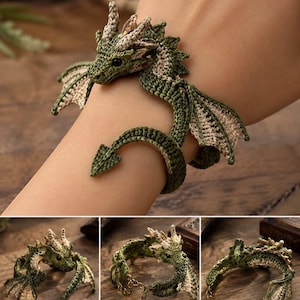 May include: A crochet dragon bracelet featuring a green and beige yarn body with detailed wings, a spiked crest, and a small black eye. The design wraps around the wrist, with a metal chain extension and a leaf-shaped charm at the end of the tail.