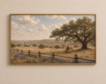 May include: A framed landscape print featuring a wide, golden-hued field with a wooden fence in the foreground, a large tree providing shade to a grazing longhorn cow, and a distant hilly horizon under a sky filled with scattered white clouds.