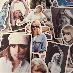 May include: A collection of assorted stickers featuring various photographic portraits and performance images of Taylor Swift, showcasing different outfits, hairstyles, and expressions in both color and black and white printed formats.