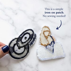May include: Two embroidered patches. One patch features a black and white circular design. The other patch depicts a tan and white figure on a white base. Text reads: This is a simple iron on patch. No sewing needed!