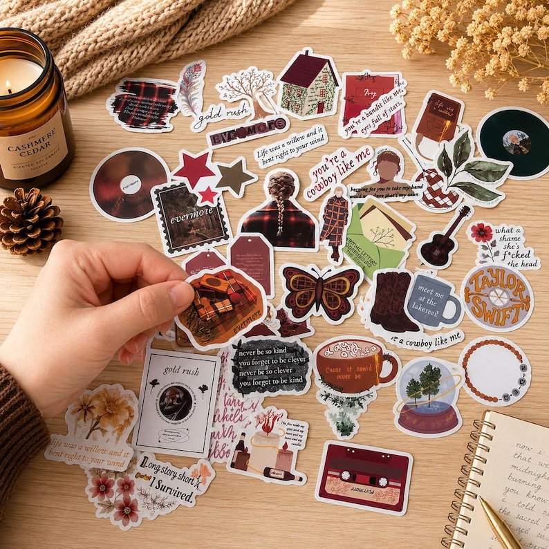 Pode incluir: Uma cole&ccedil;&atilde;o de autocolantes decorativos com v&aacute;rios desenhos, incluindo uma casa, uma borboleta, uma guitarra e texto. Os autocolantes apresentam uma mistura de cores, incluindo vermelho, castanho e branco. Alguns autocolantes t&ecirc;m texto como "evermore" e "gold rush".