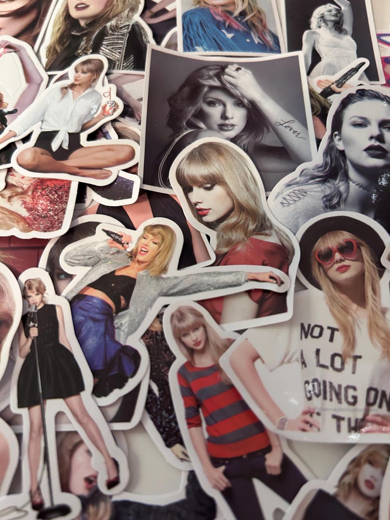 May include: A collection of die-cut vinyl stickers featuring various photographic portraits and performance shots of Taylor Swift. The stickers display diverse outfits, hairstyles, and poses, including one with the text NOT A LOT GOING ON AT THE MOMENT.