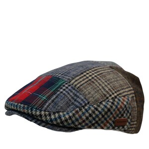 May include: A patchwork flat cap featuring a mix of plaid and patterned fabrics in shades of blue, brown, and red. The cap has a small, brown leather tag on the side. A stylish accessory for any wardrobe.
