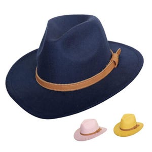 Puede incluir: Un sombrero fedora azul marino con una banda de cuero marrón. El sombrero tiene un ala ancha y una corona pellizcada. También se muestran dos sombreros más pequeños en rosa y amarillo.