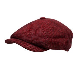 May include: A flat cap featuring a dark red and black herringbone pattern. The cap has a rounded crown with a small button at the top center and a short, stiff brim extending from the front. The fabric displays a consistent woven texture.