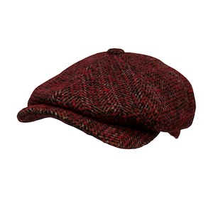 Peut inclure: Casquette de style gavroche en tissu à motif chevrons rouge et noir. La casquette a une couronne arrondie et une visière courte et rigide. Le tissu présente un aspect texturé. Un accessoire de mode classique et intemporel.