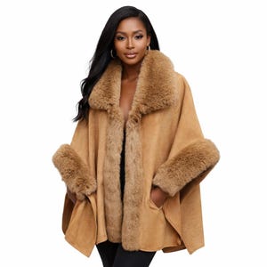 May include: A tan suede-like cape featuring a wide, plush faux fur collar and matching faux fur trim along the front opening and sleeve cuffs. The garment has an open front design with integrated side pockets and a soft, textured finish.