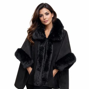 Peut inclure: Une cape noire dotée d'un col en fausse fourrure douce et pelucheuse, avec une bordure assortie le long de l'ouverture avant et des poignets. Le vêtement présente une texture mate lisse et des poches latérales pour une silhouette structurée.
