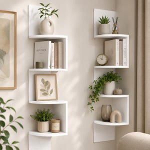 May include: Two white corner shelves with a zig-zag design are mounted on a beige wall. The shelves are decorated with books, plants, candles, and decorative objects. The shelves are a stylish storage solution.