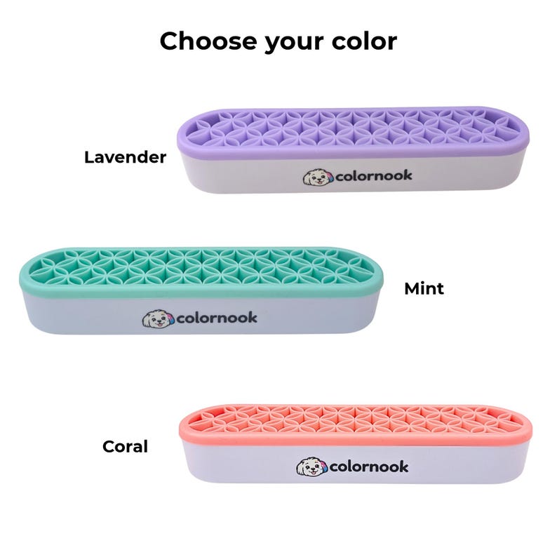 May include: Three elongated oval organizers with white bases and the text colornook featuring a dog logo. Each has a silicone top with a geometric flower pattern in lavender, mint, or coral. The text Choose your color is at the top.