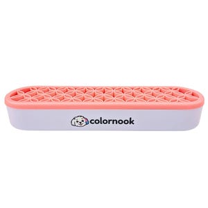 May include: A rectangular white organizer with a coral pink top featuring a repeating geometric flower pattern. The front side displays a small graphic of a dog with a colorful ear and the text colornook in black lowercase letters.