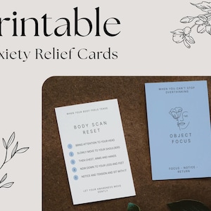 May include: Printable anxiety relief cards. One card reads "Body Scan Reset" with instructions. The other card reads "Object Focus" with a floral illustration and the text "Focus - Notice - Return". The cards are on a brown surface.