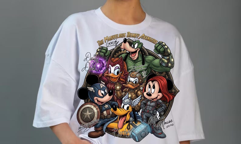 May include: White t-shirt featuring a graphic of Disney characters as Avengers. The design includes Mickey Mouse as Captain America, Minnie Mouse as Black Widow, and Goofy. Text includes "The Marvelous Disney Avengers" and character names.