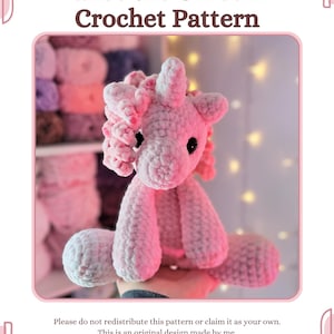 Könnte beinhalten: Handgefertigtes rosa Häkel-Einhorn namens Bailee. Das Einhorn hat eine flauschige Mähne, ein Horn und schwarze Augen. Das Bild enthält den Text "Bailee the Unicorn Crochet Pattern" und Anweisungen.
