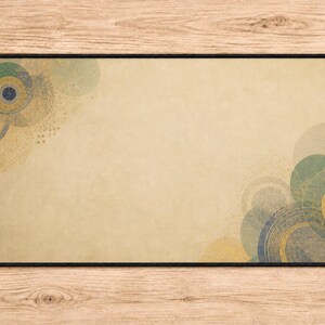 May include: A rectangular desk mat with a beige, parchment-like background featuring overlapping circular patterns in shades of muted teal, navy blue, and gold. The design is concentrated in the top-left and bottom-right corners with a black border.