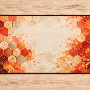May include: A rectangular desk mat featuring a central cream-colored area surrounded by a border of orange, red, and brown hexagons. The hexagons contain various intricate patterns, including floral motifs and geometric shapes, with scattered leaf designs.
