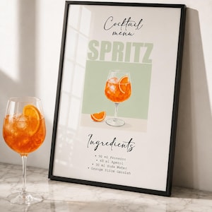 Può includere: Una stampa da parete incorniciata intitolata Cocktail menu SPRITZ con l'illustrazione di un cocktail arancione in un bicchiere con una fetta d'arancia. Il testo elenca gli ingredienti: 90 ml Prosecco, 60 ml Aperol, 30 ml Soda Water e Orange Slice Garnish.