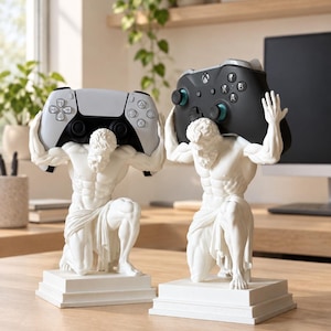 May include: Two white statues of kneeling figures on square bases, each holding a gaming controller above their heads. One figure supports a white and black controller, while the other holds a black controller with blue accents on the analog sticks.
