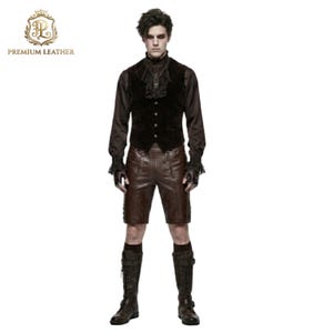 May include: A dark brown velvet vest with a ruffled collar, a long-sleeved brown shirt with lace cuffs, brown leather shorts, and tall brown lace-up boots. The outfit includes fingerless gloves and a dark pendant necklace on a chain.