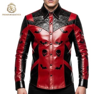 Puede incluir: Una camisa de manga larga con botones hecha de cuero rojo y negro. La camisa presenta un cuello negro, paneles de hombro negros en relieve y apliques de cuero negro con formas de murciélagos y calaveras. El texto PREMIUM LEATHER es visible.