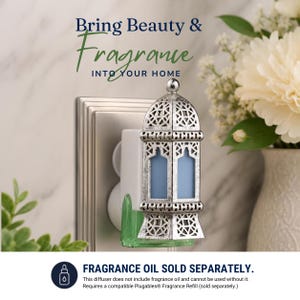 May include: A silver-toned metal wall plug-in fragrance diffuser featuring an intricate lattice lantern design with a light blue center panel. Text reads: Bring Beauty & Fragrance INTO YOUR HOME and FRAGRANCE OIL SOLD SEPARATELY.
