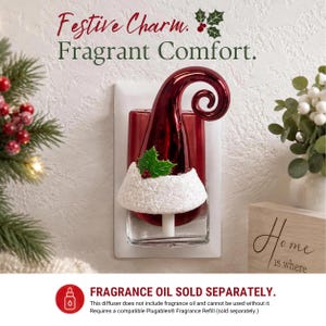 May include: A wall plug-in fragrance diffuser featuring a shiny red, curled hat design with a white glittery brim, a green holly leaf, and red berries. The text reads: Festive Charm. Fragrant Comfort. FRAGRANCE OIL SOLD SEPARATELY.