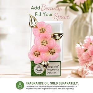 May include: A white wall plug-in fragrance diffuser featuring a cluster of four translucent pink flowers with gold centers and gold leaves. The base is green with the text Belle Aroma Plugables Fragrance Diffuser. Text above reads Add Beauty. Fill Your Space.