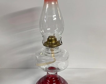 Lámpara de aceite antigua, pintada en rojo rubí brillante.