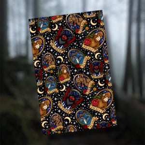 May include: A black notebook with a repeating pattern of cryptid illustrations. The design includes images of Bigfoot, bats, and other creatures, each framed in an oval with a banner. The background is filled with stars and crescent moons.