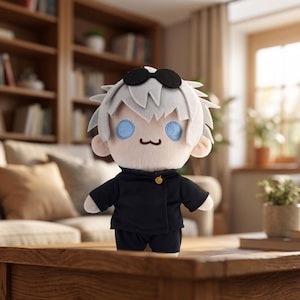 Könnte beinhalten: Plüschpuppe einer Figur mit weißen Haaren, blauen Augen und schwarzer Sonnenbrille. Die Puppe trägt eine schwarze Uniform mit einem goldenen Knopf. Die Puppe steht auf einem Holztisch vor einem verschwommenen Hintergrund.