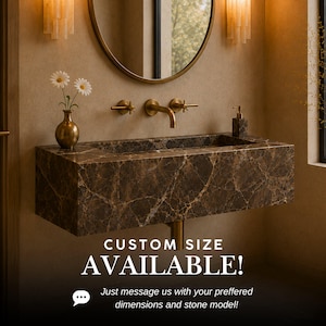 May include: A wall-mounted rectangular bathroom sink crafted from dark brown marble with prominent white veining. It features a brass faucet with two cross-handle controls, a brass vase with two white daisies, and a soap dispenser. Text reads: CUSTOM SIZE AVAILABLE! Just message us with your preferred dimensions and stone model!