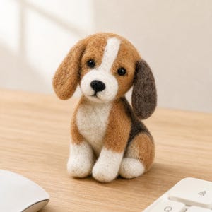 May include: A handcrafted felt beagle dog figurine. The dog has brown, white, and black markings, with floppy ears and a sweet expression. It is sitting on a wooden surface, near a computer mouse and keyboard.