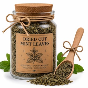 May include: A glass jar filled with dried cut mint leaves, sealed with a cork lid and twine. A wooden spoon holds a portion of the leaves, with fresh mint sprigs nearby. The label reads "Dried Cut Mint Leaves".