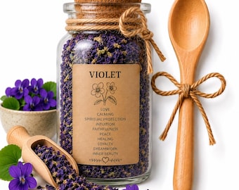 May include: A glass jar filled with dried violet flowers, a wooden spoon, and a small bowl of fresh violets. The jar has a cork stopper and a label that reads "VIOLET" with associated words like "Love" and "Calming". The spoon is tied with twine.