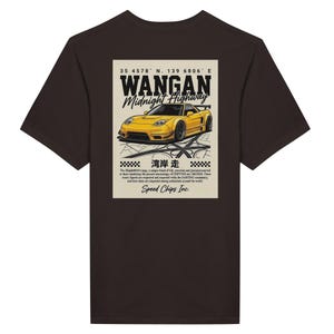 May include: Dark brown t-shirt featuring a graphic of a yellow sports car with the text "WANGAN Midnight Highway." The design includes Japanese text and the words "Speed Chips Inc."