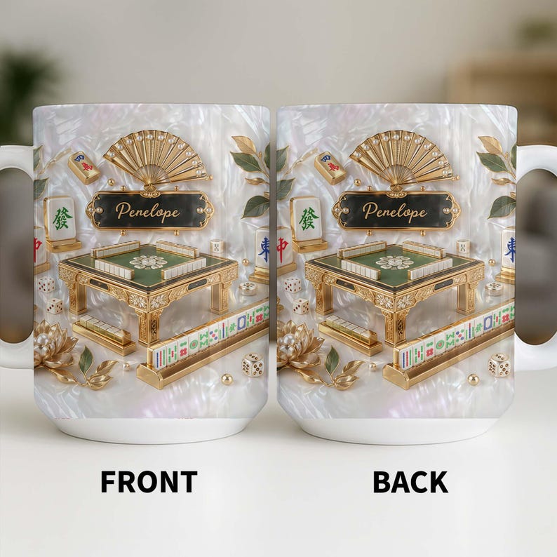May include: White ceramic mug featuring a detailed design of a Mahjong table, fan, and tiles. The mug has a pearlescent background and the name "Penelope" on a plaque. The front and back of the mug are visible.