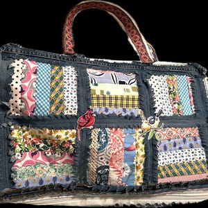May include: A denim tote bag with patchwork squares of various patterned fabrics. The bag features a floral patterned handle and is embellished with a red cardinal and a bird with a floral branch.
