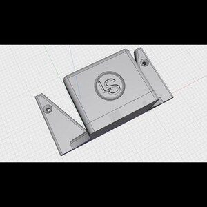 May include: A 3D-rendered, gray, geometric object with the letters "LS" in a circle on the top surface. The object has a rectangular base with two angled side pieces, each with a circular hole.