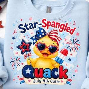 May include: A light blue sweatshirt featuring a graphic of a yellow duckling wearing heart-shaped sunglasses and a patriotic bow. The text reads Star-Spangled Quack July 4th Cutie, surrounded by red, white, and blue stars, fireworks, and a popsicle.