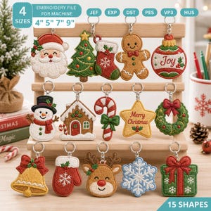 May include: A collection of 15 embroidered Christmas-themed keychains displayed on a wooden stand. Designs include Santa, a tree, stocking, gingerbread man, ornament with 'Joy', snowman, house, candy cane, star with 'Merry Christmas', wreath, bell, mitten, reindeer, snowflake, and gift.